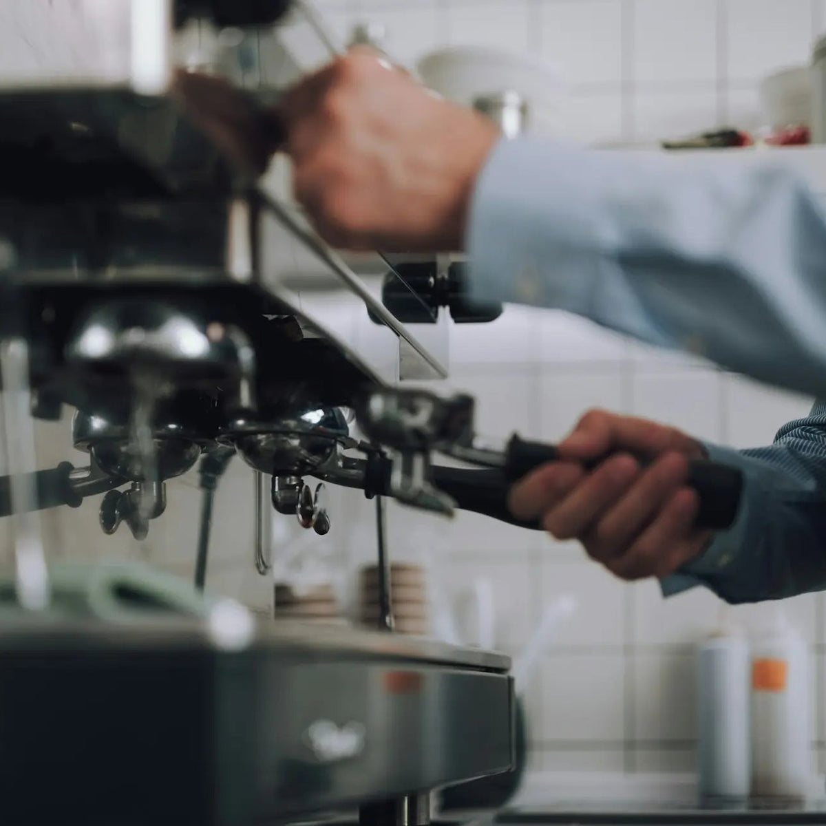 Technician servicing a commercial espresso machine in a restaurant kitchen